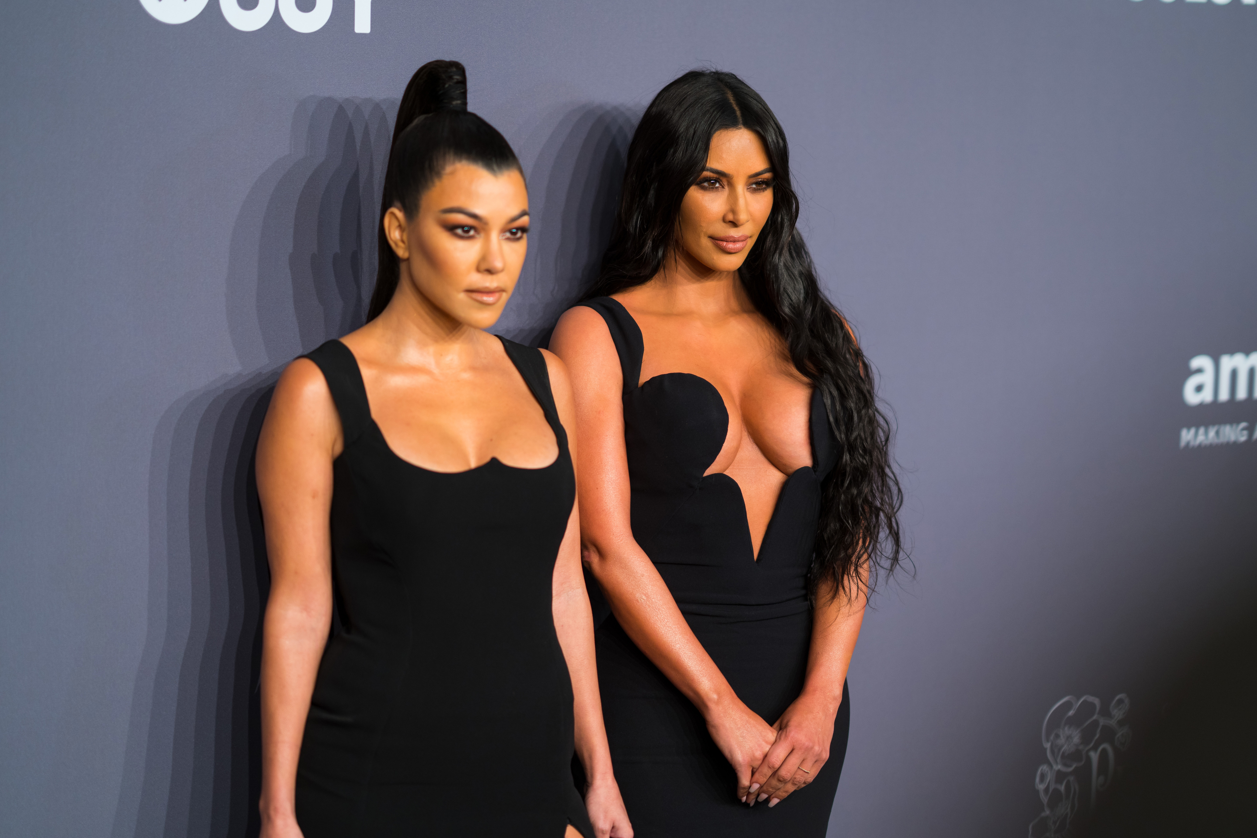 Close-up of Kourtney and Kim Kardashian at a media event