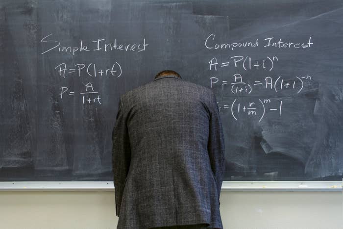 A man standing in front of a chalkboard comparing simple interest and compound interest