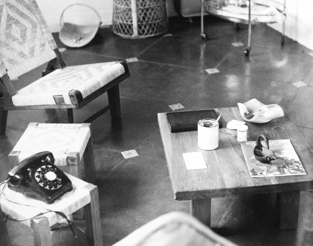 her room with a small table, chairs, and a telephone