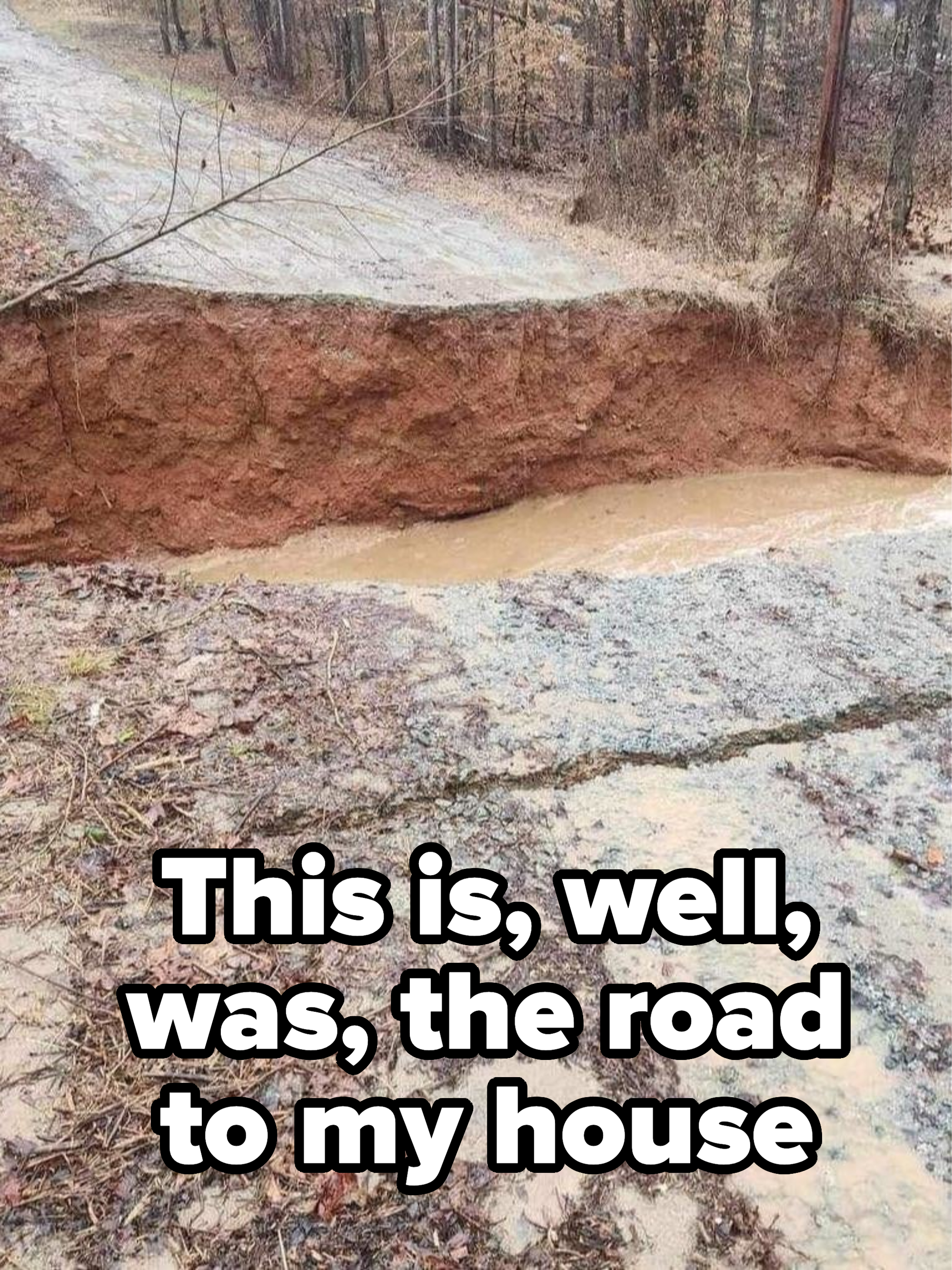 &quot;This is, well, was, the road to my house&quot;: A road that looks split in half with muddy water running across it