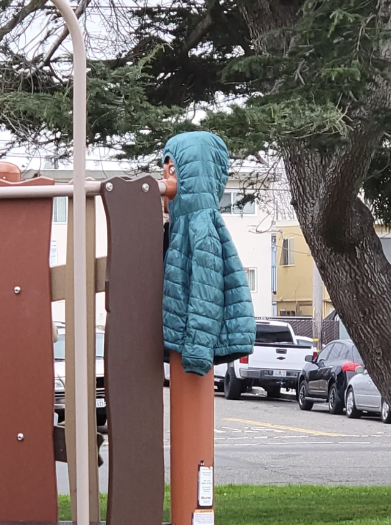 jacket hanging over a post that looks like it could be a person