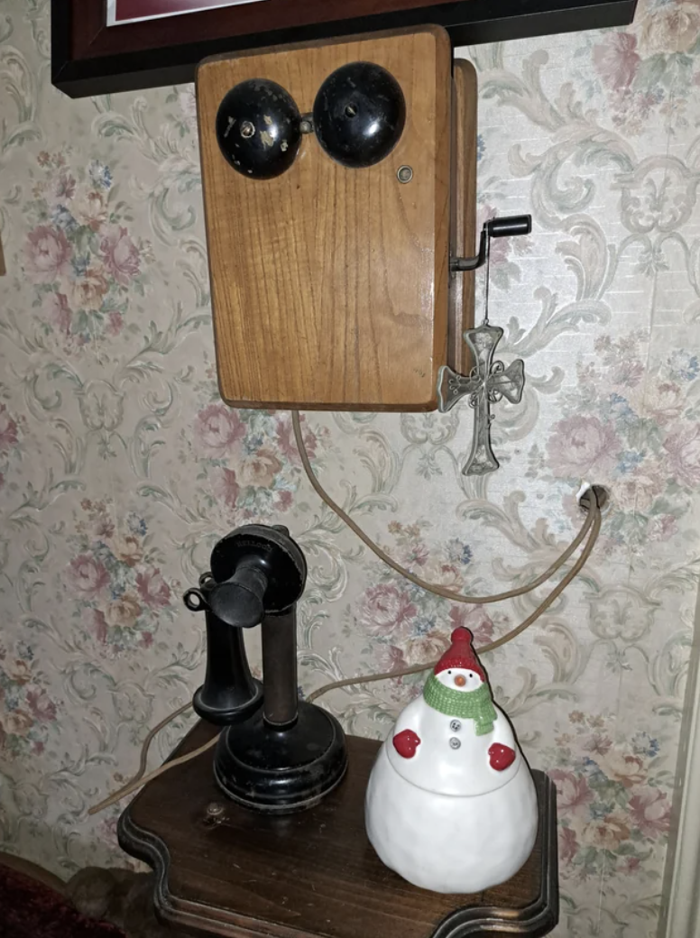 a box wired into the wall with the receiver and ear piece on a table underneath