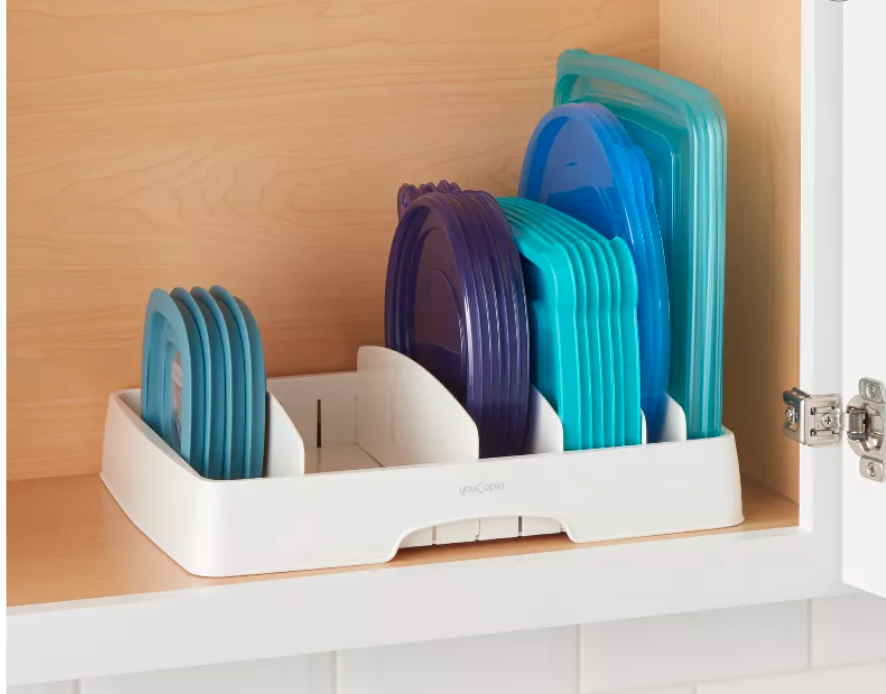 a plastic lid organizer holding tupperware lids in a kitchen cabinet