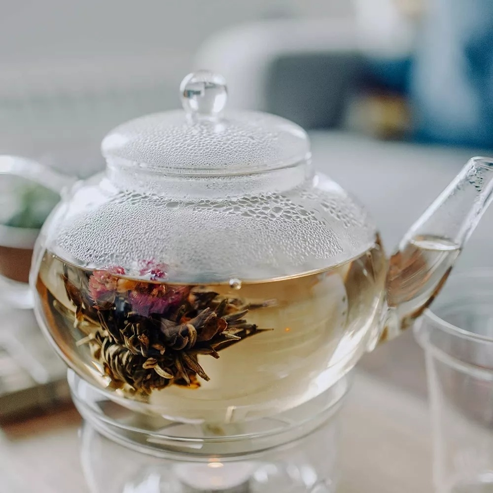 Clear teapot with blooming flower tea, ideal for elegant tea time shopping