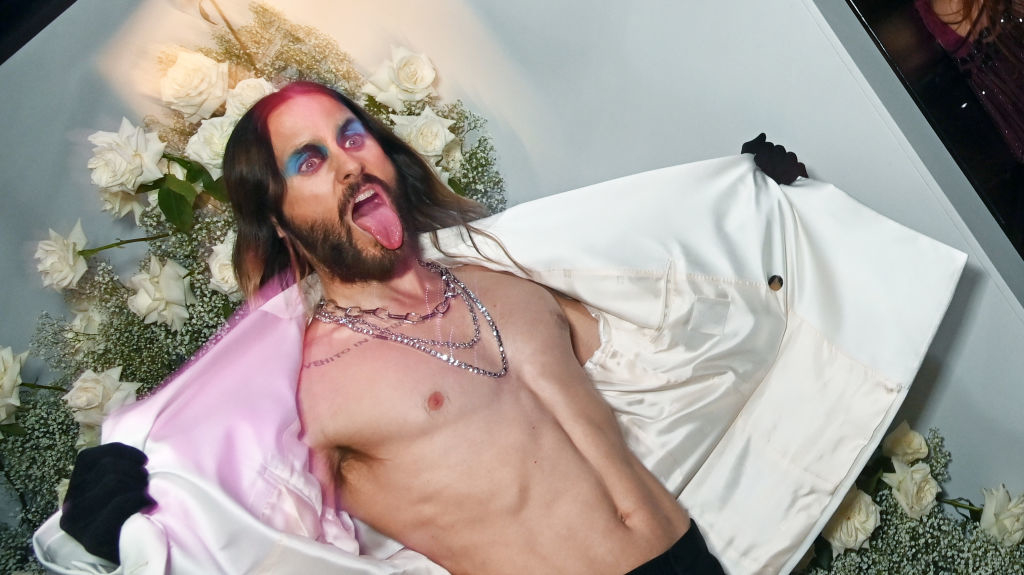 Jared opening his jacket to expose his bare chest while sticking his tongue out