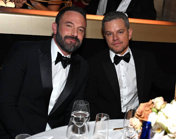 Closeup of Ben Affleck and Matt Damon sitting at an awards table