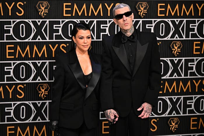 Closeup of Kourtney Kardashian and Travis Barker with both wearing suits