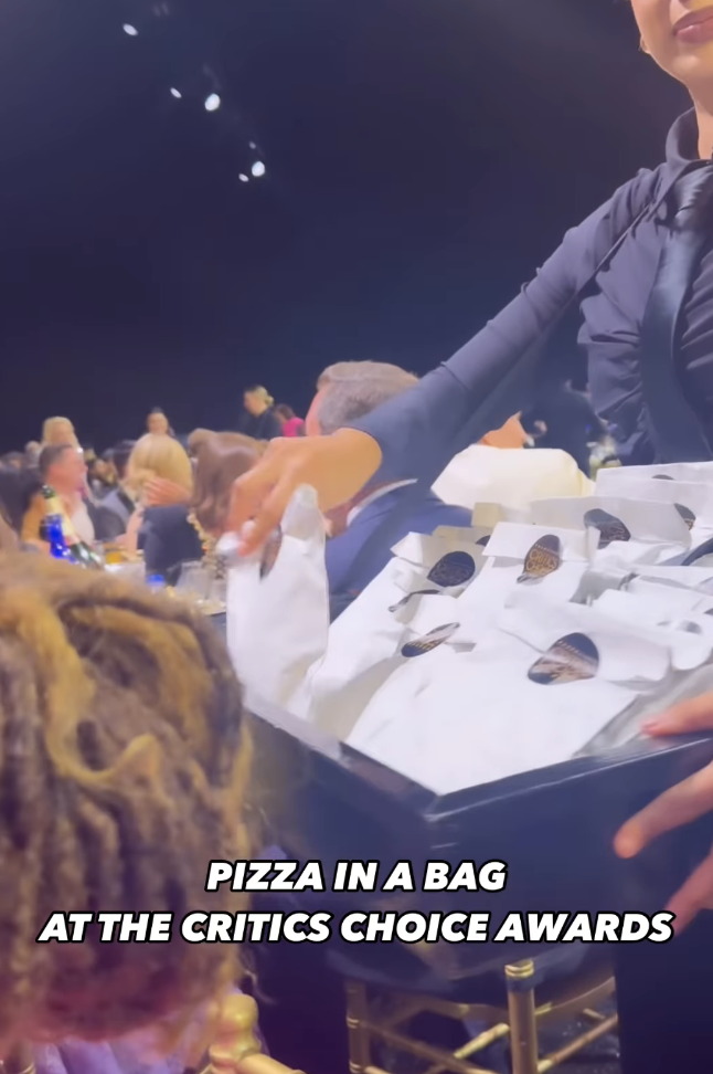 A woman handing out individual pizza slices in bags