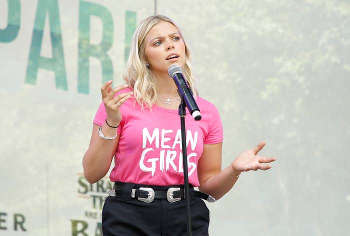 Reneé Rapp singing onstage while wearing a shirt that says &quot;Mean Girls&quot;