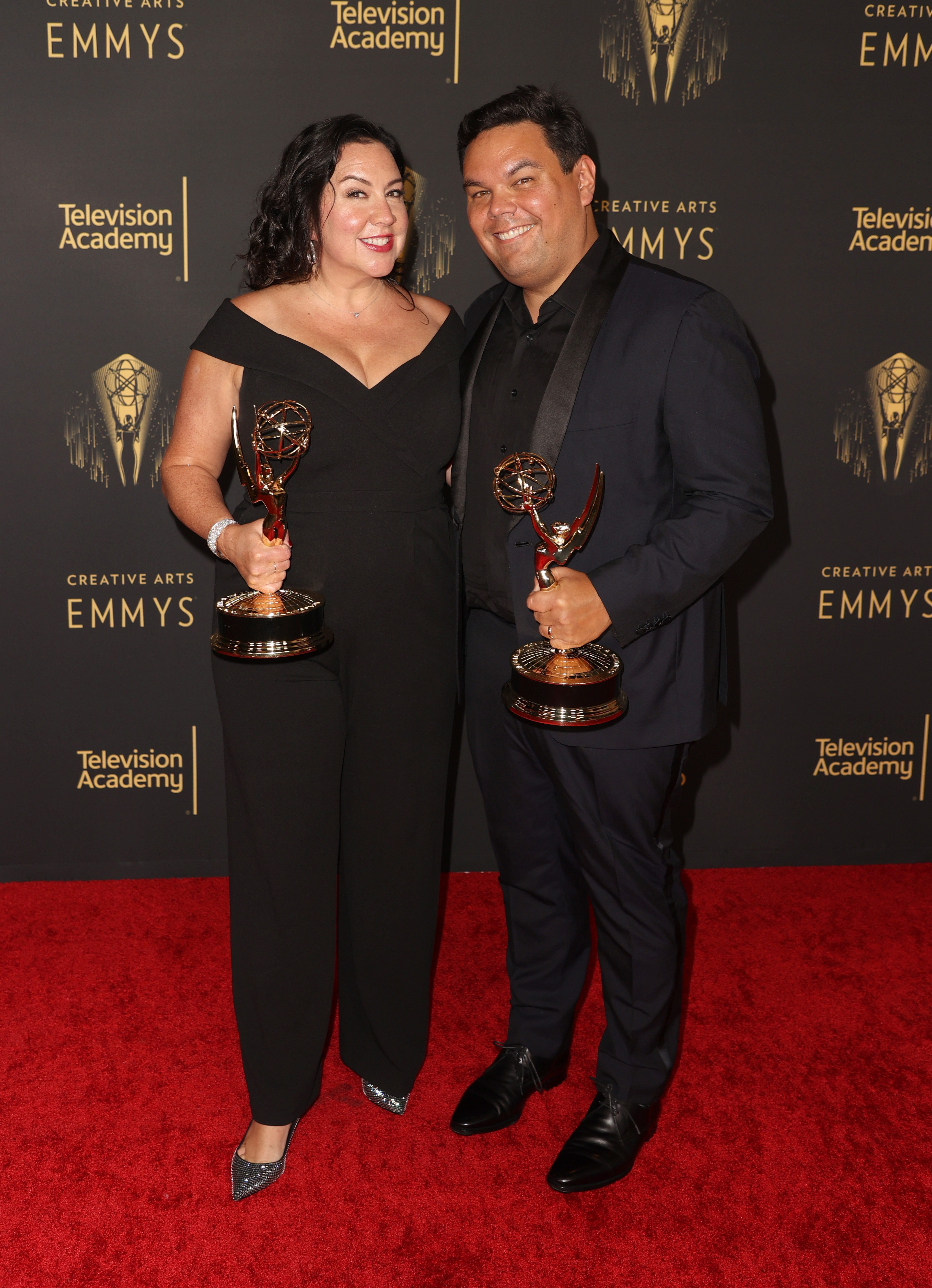 Robert Lopez and his partner holding their Emmys
