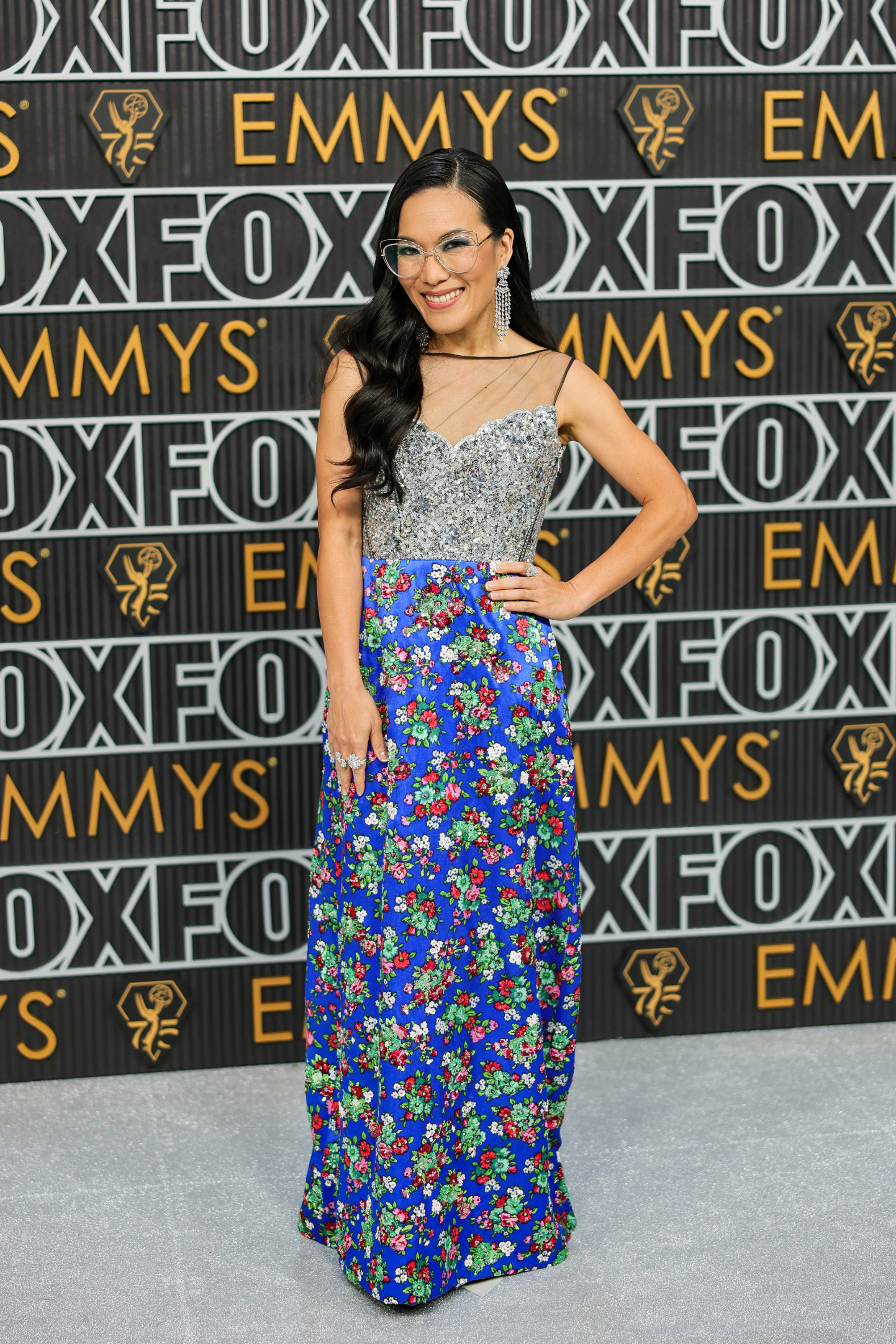 Ali Wong poses on the red carpet with her hand on her hip