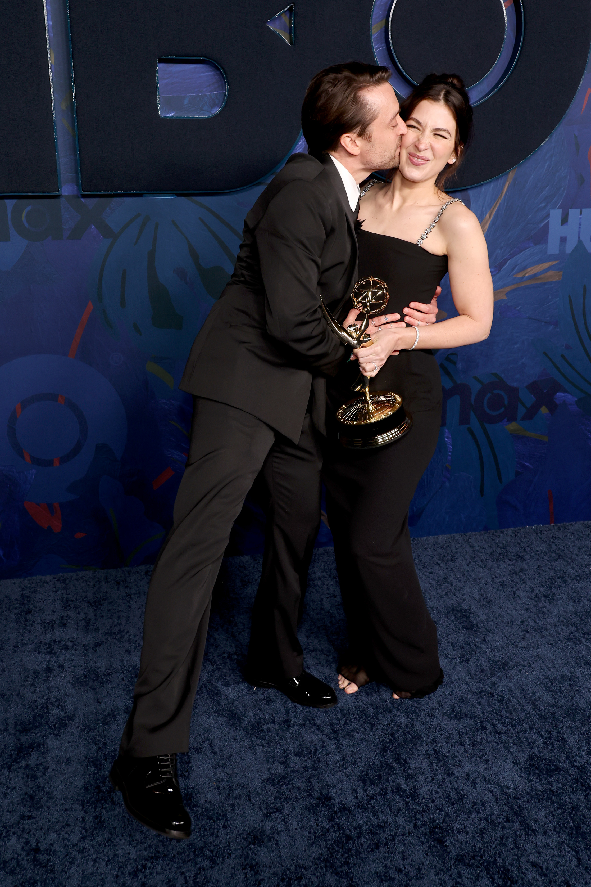 Kieran kisses Jazz on her cheek as he holds his award
