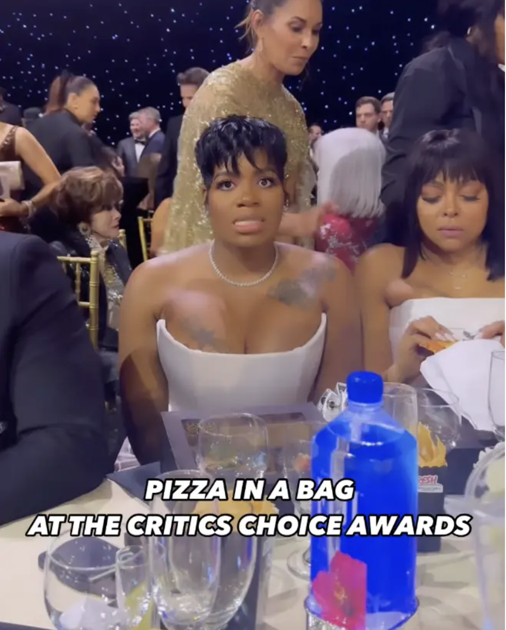 Fantasia Barrino looks grossed out sitting at a table with text pizza in a bag