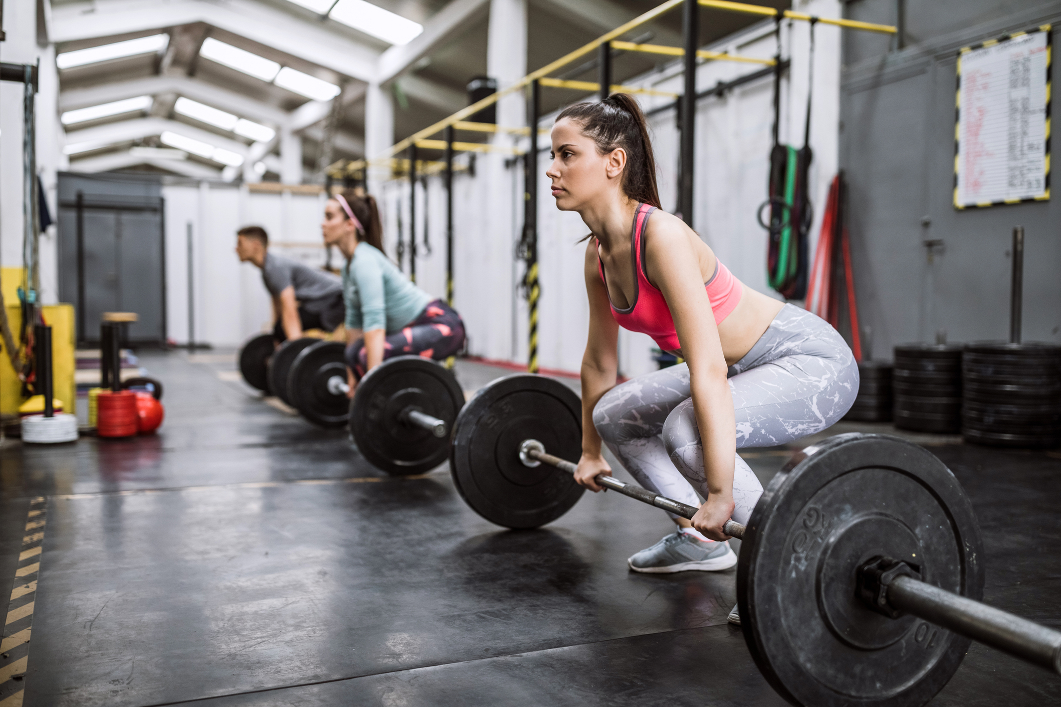 A woman is deadlifting at the gym