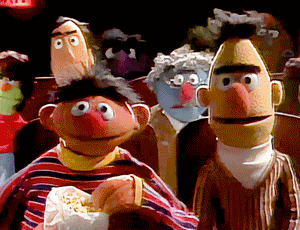 Burt and Ernie from Sesame Street in a movie theater eating popcorn