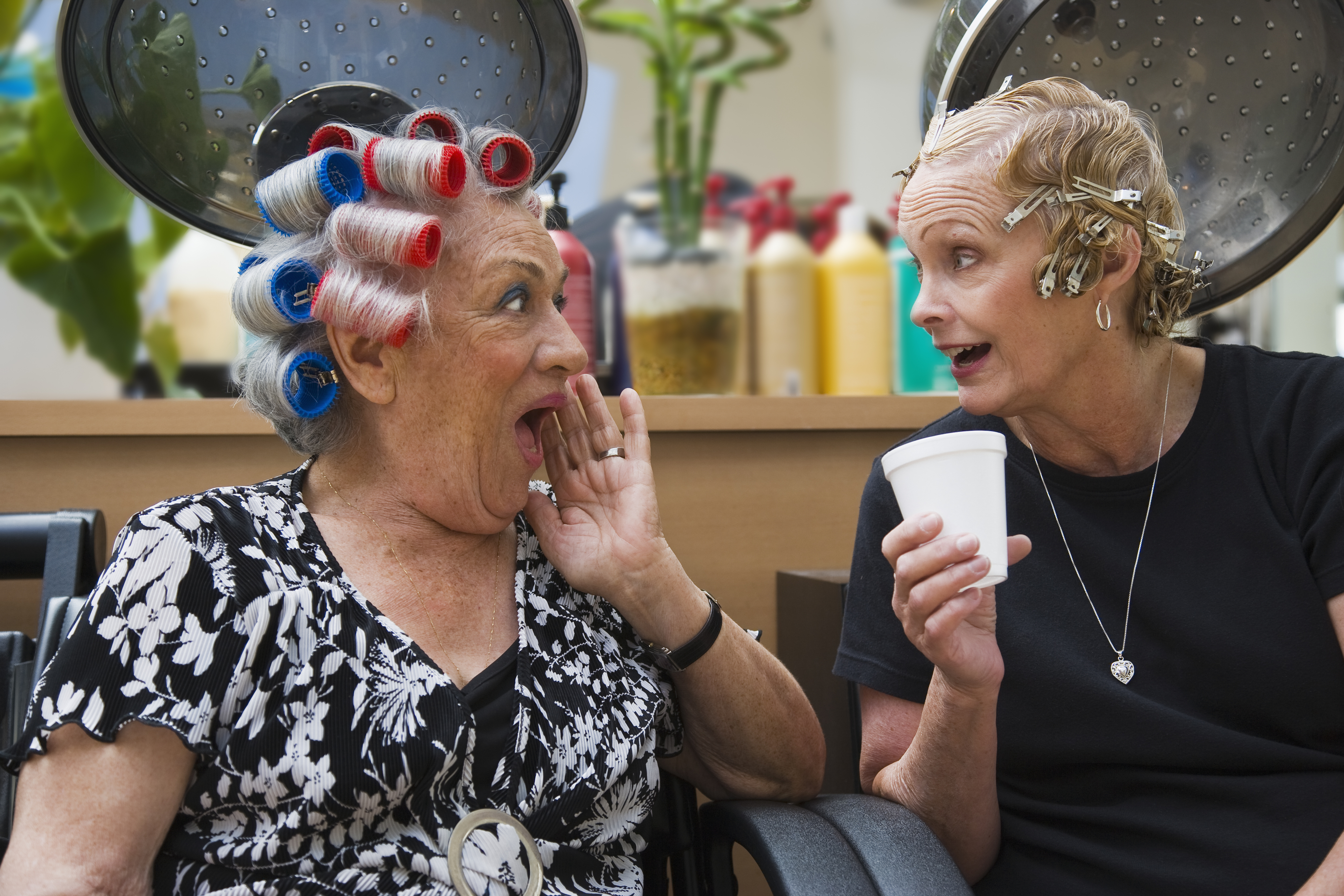 Two older women gossiping in a beauty salon