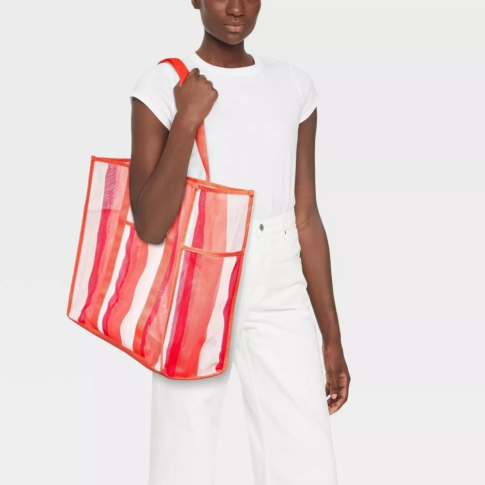model carrying striped pink beach bag