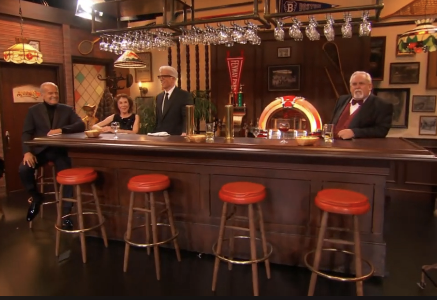 the cast sitting at a bar