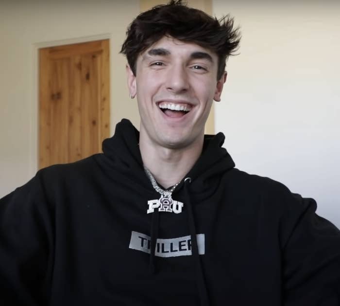 A young man smiling and wearing a hoodie
