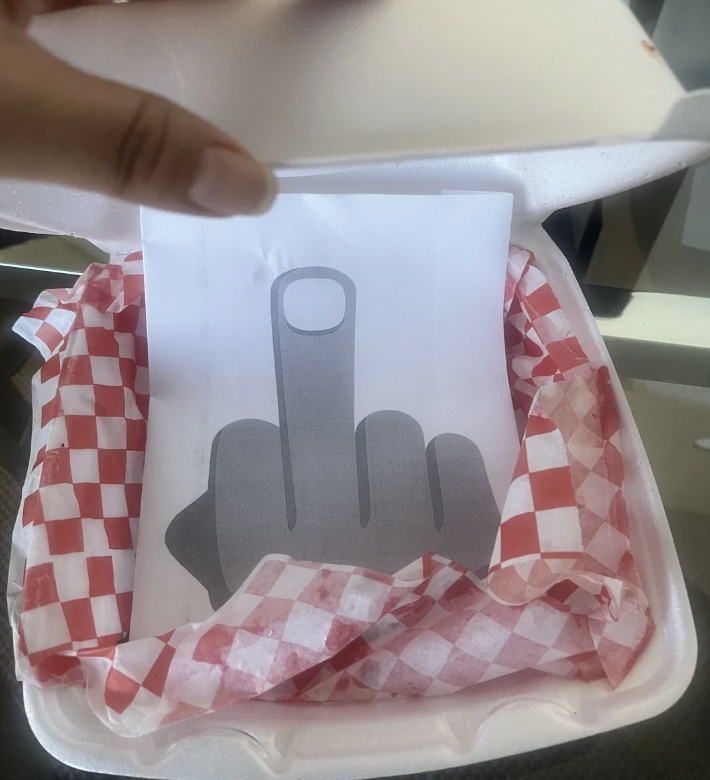 A paper with a hand giving the middle finger
