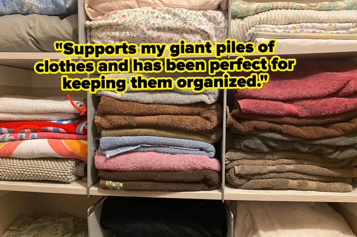 reviewer photo of shelf dividers dividing stacks of folded towels with reviewer quote on the image "supports my giant piles of clothes and has been perfect for keeping them organized"