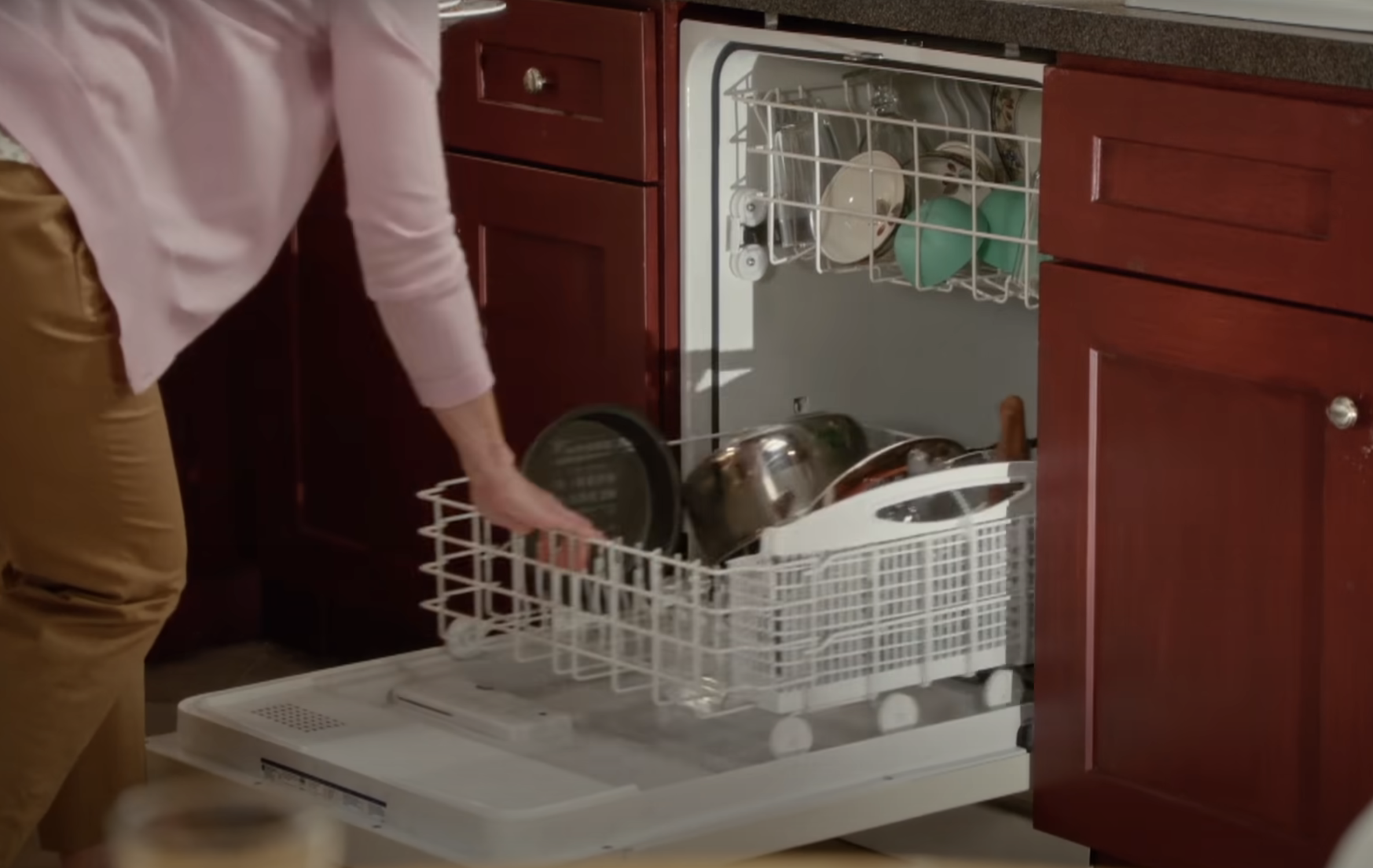 A person loading a dishwasher