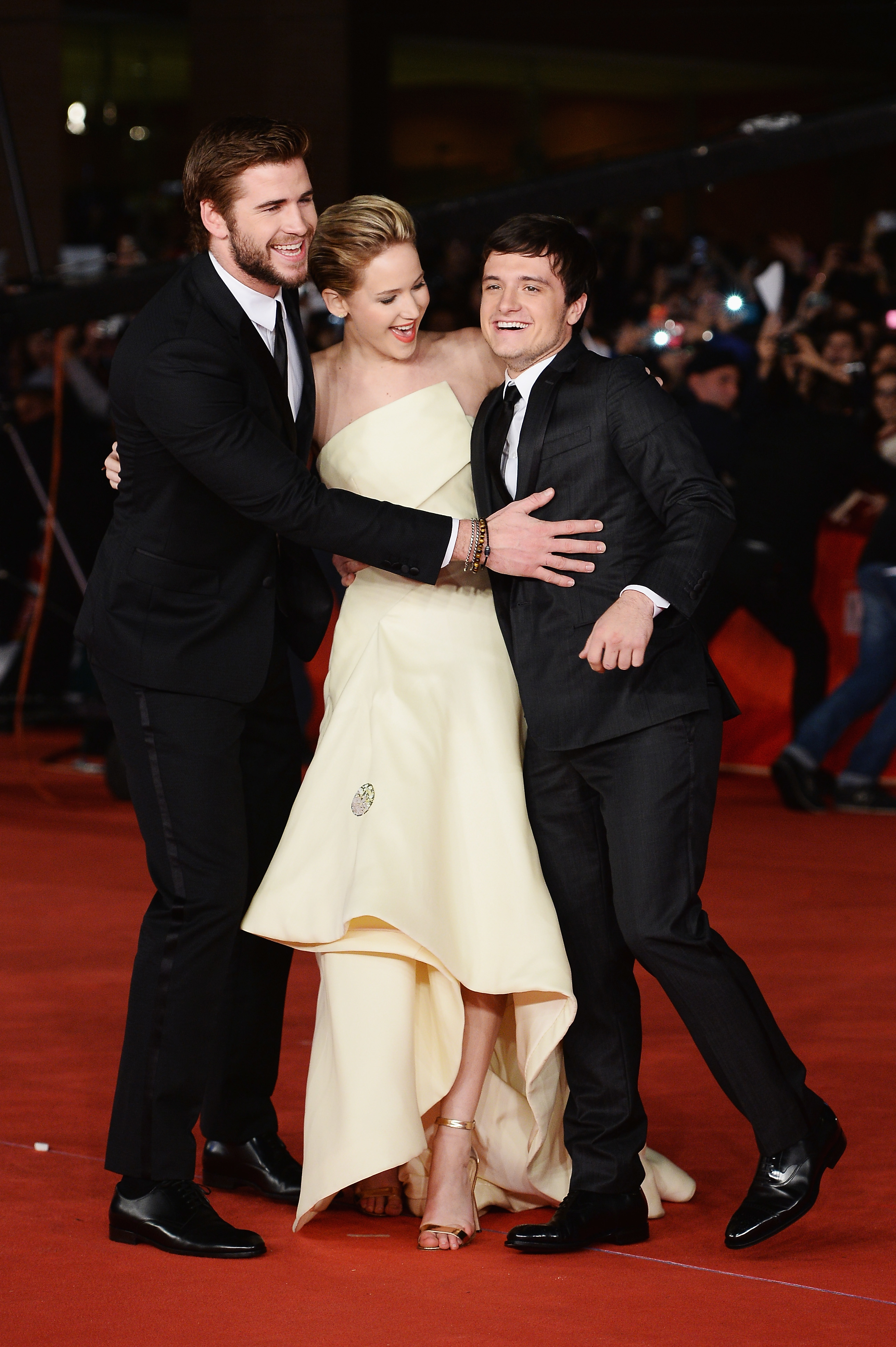 Liam Hemsworth, Jennifer Lawrence, and Josh Hutcherson laughing on the red carpet
