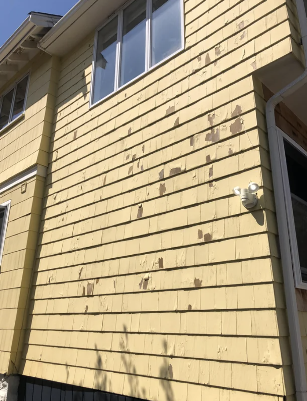 The exterior paint of a house is peeling