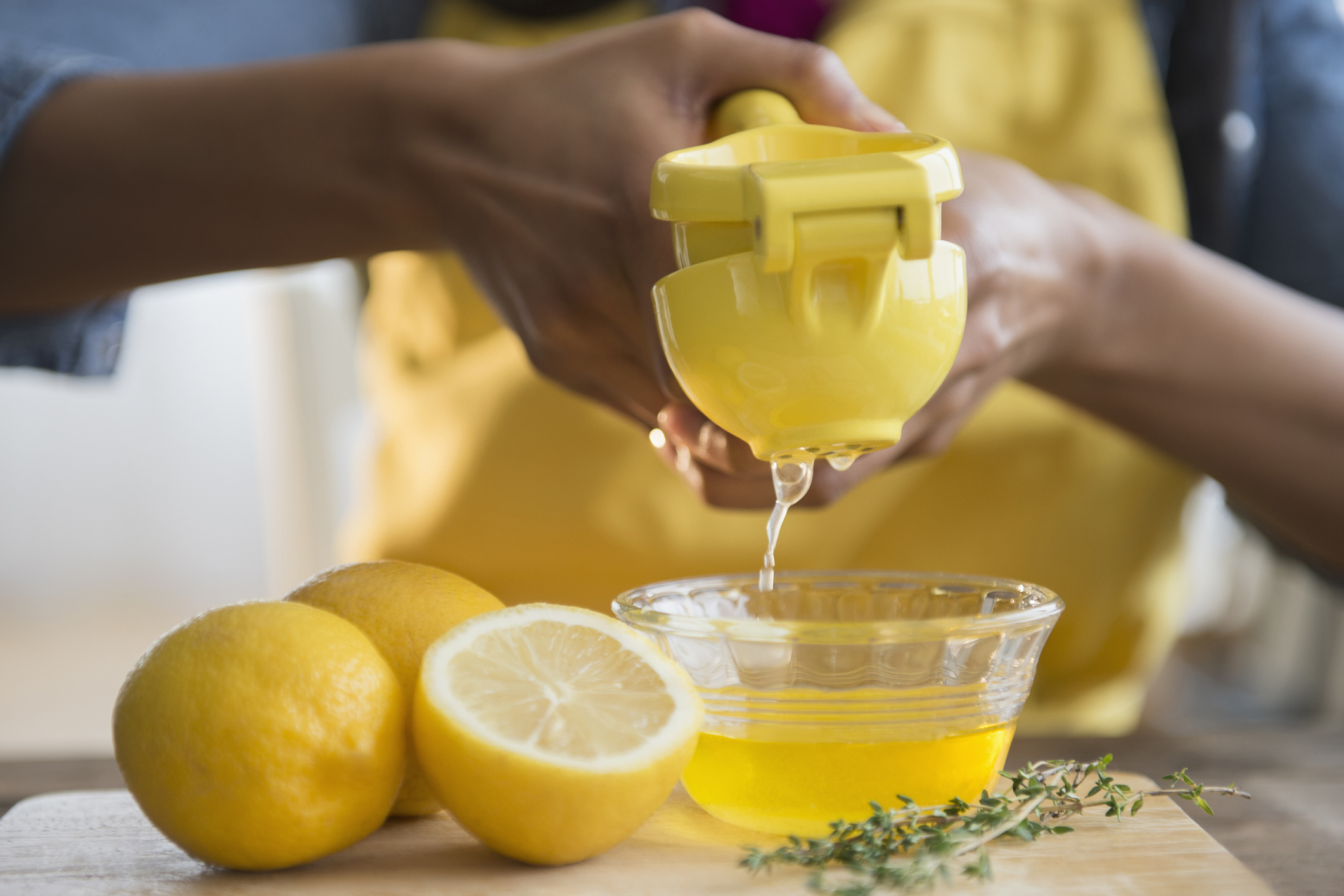 a woman squeezing the juice out of a lemon