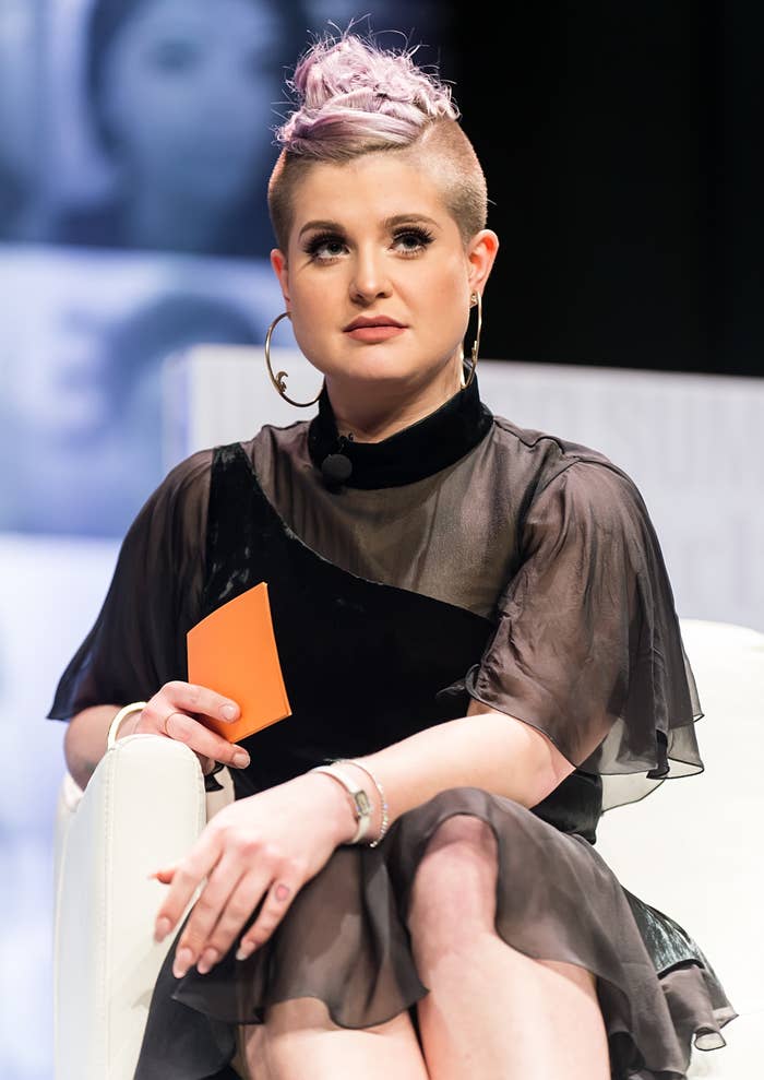 Close-up of Kelly sitting and wearing large hoop earrings