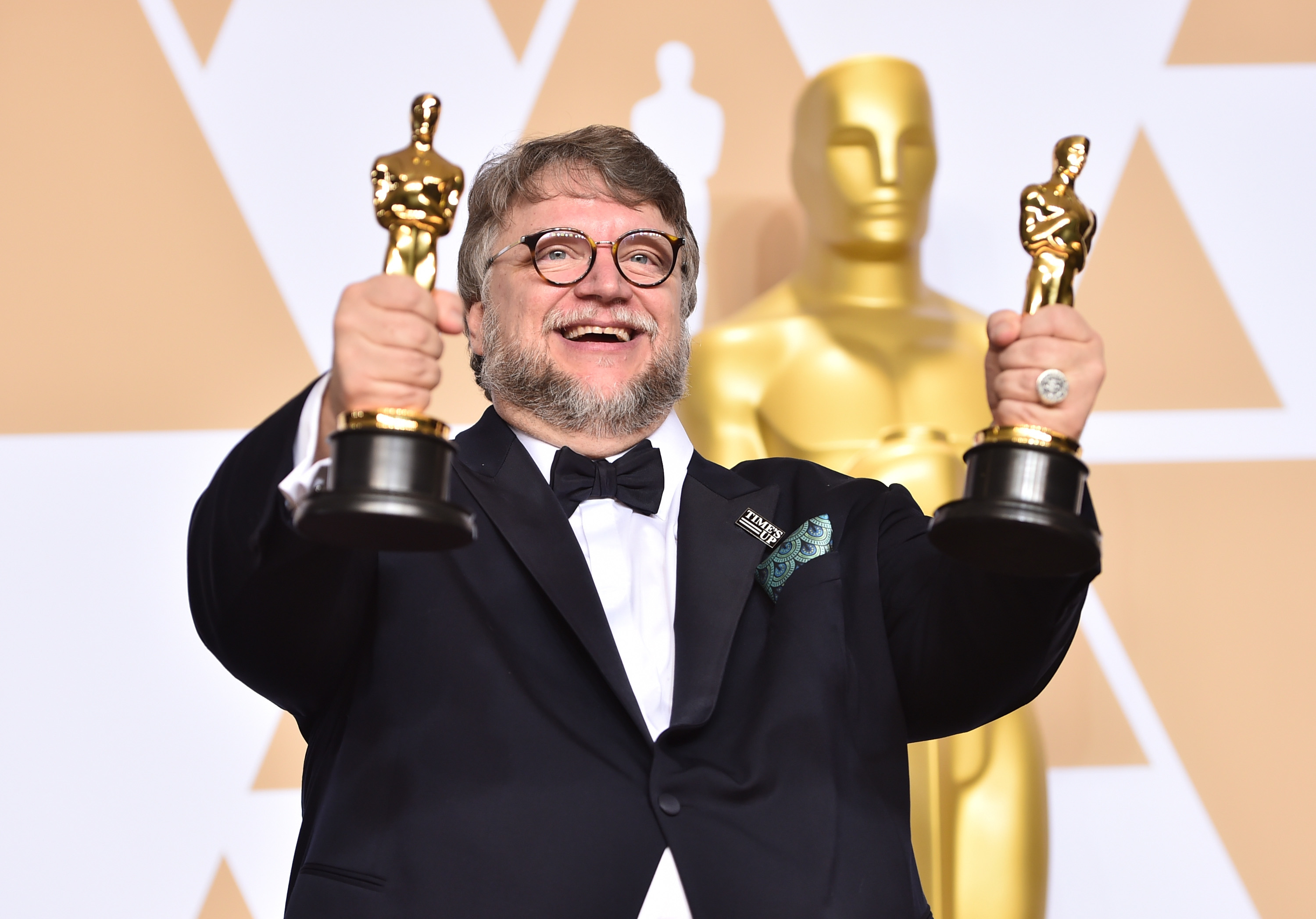 Guillermo holding up his two Oscars