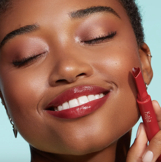 model wearing the heart-shaped Kaja lip gloss in a red shade