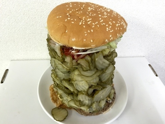very tall burger of piled pickles