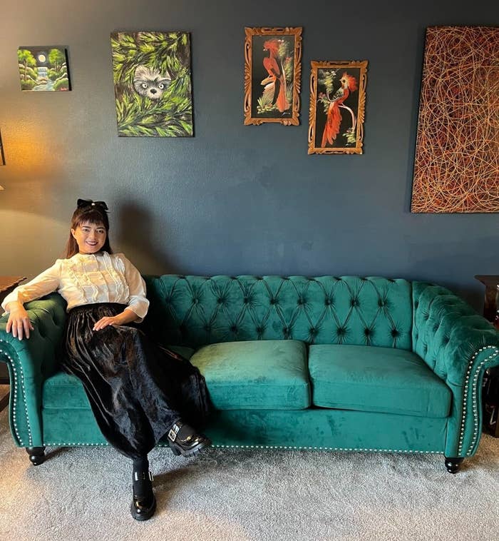 a reviewer photo of a person sitting on the green couch