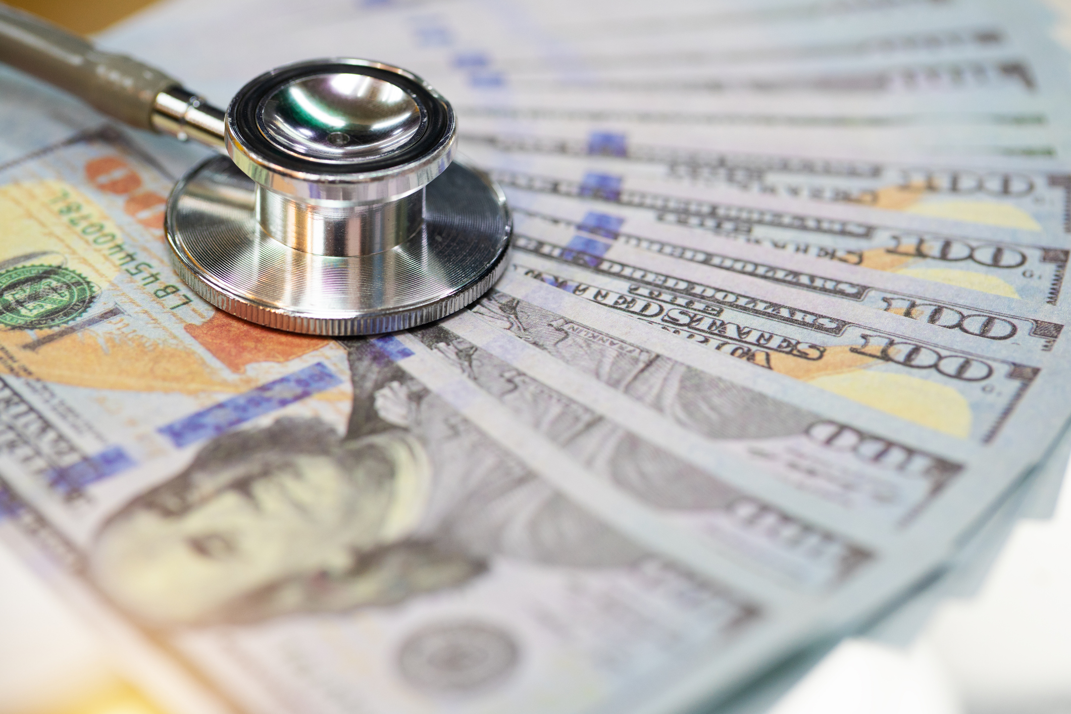 A stethoscope is lying on top of $100 bills