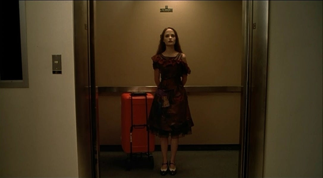 Angela Bettis standing alone in an elevator.