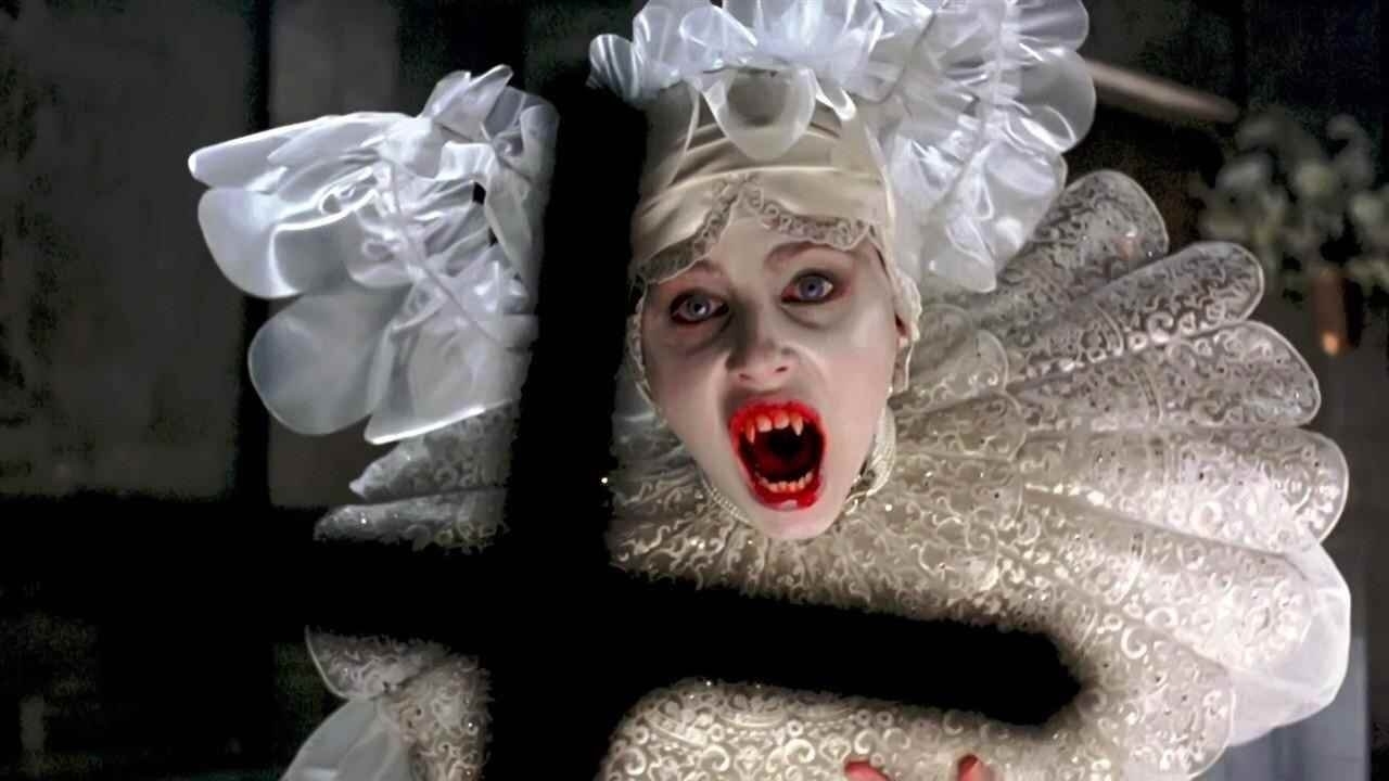 Sadie Frost baring her teeth at a crucifix.