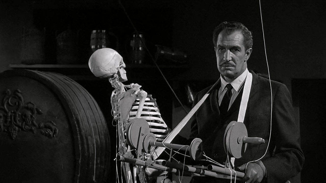 Vincent Price holding a puppet shaped like a human skeleton