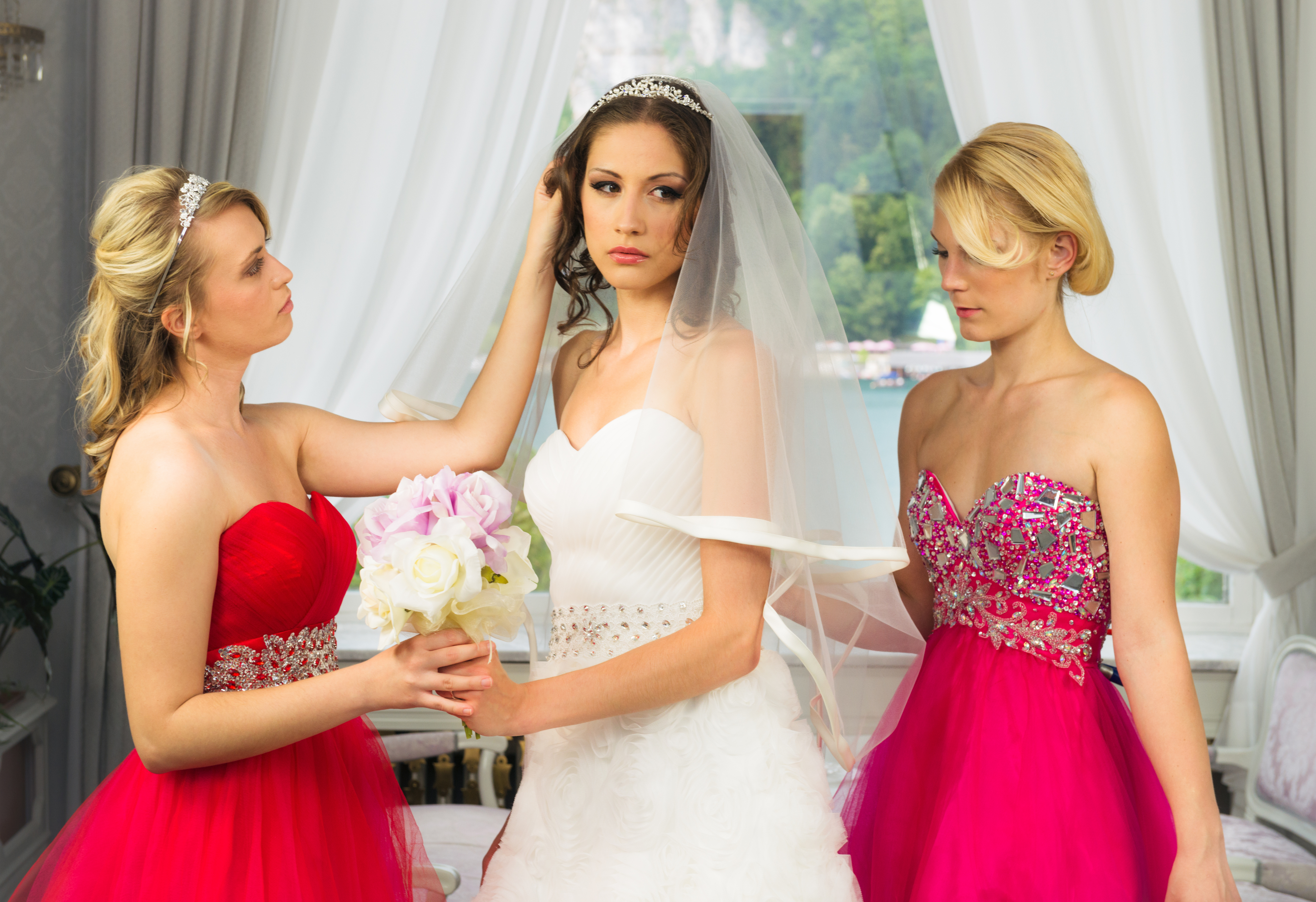 two bridesmaids helping a bride who looks visibly upset