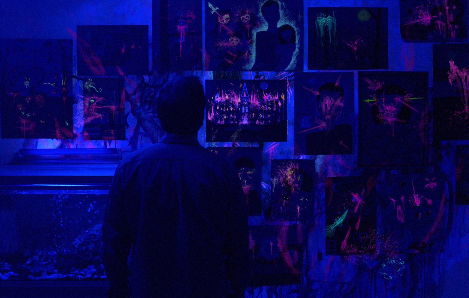 Peter Sarsgaard examining black light paintings.