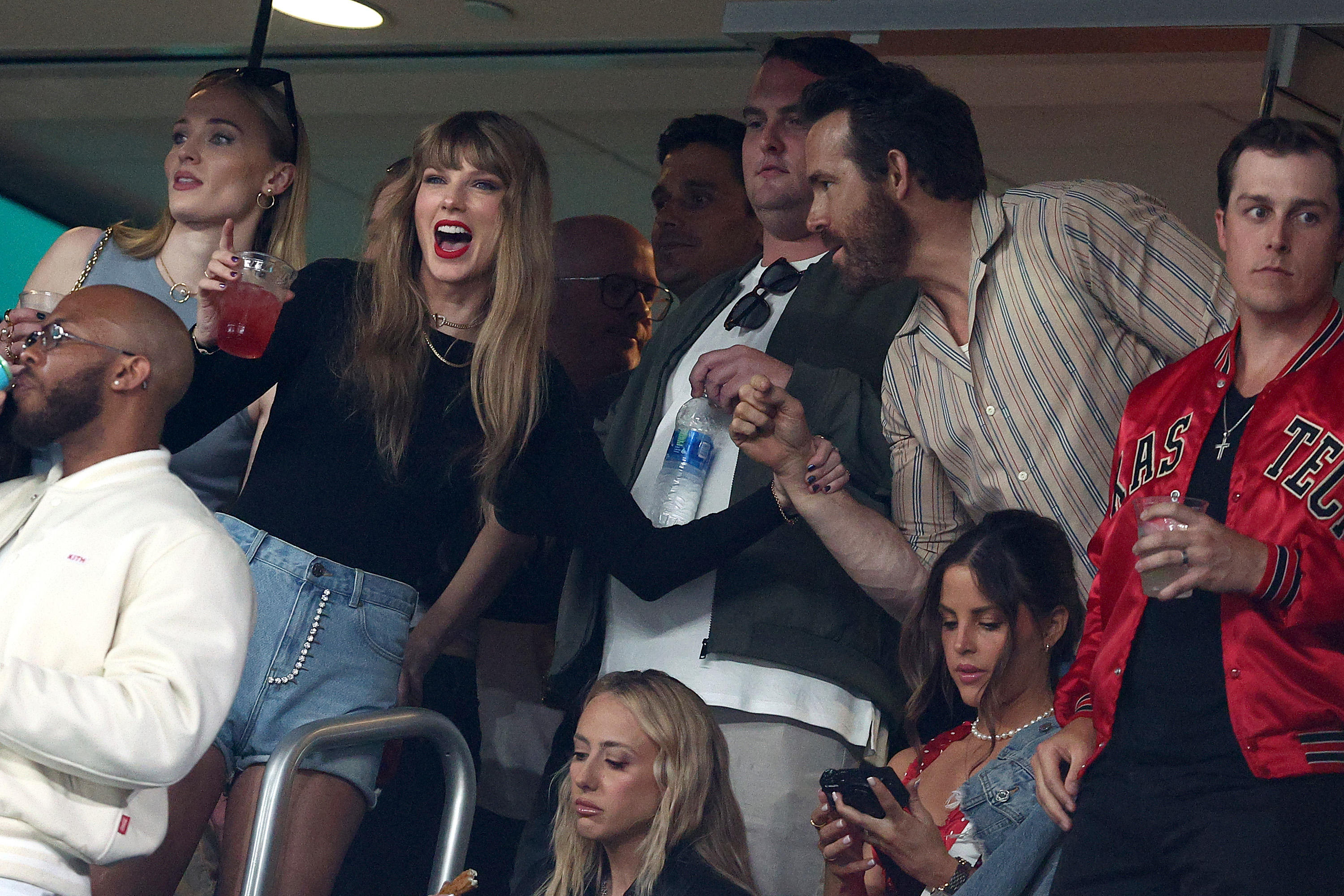 taylor cheering at the game with her friends around