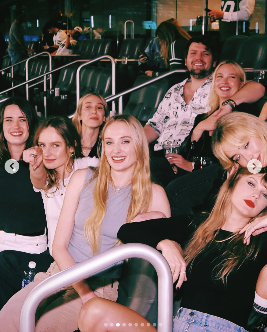taylor and sophie surrounded by friends in the stadium seats