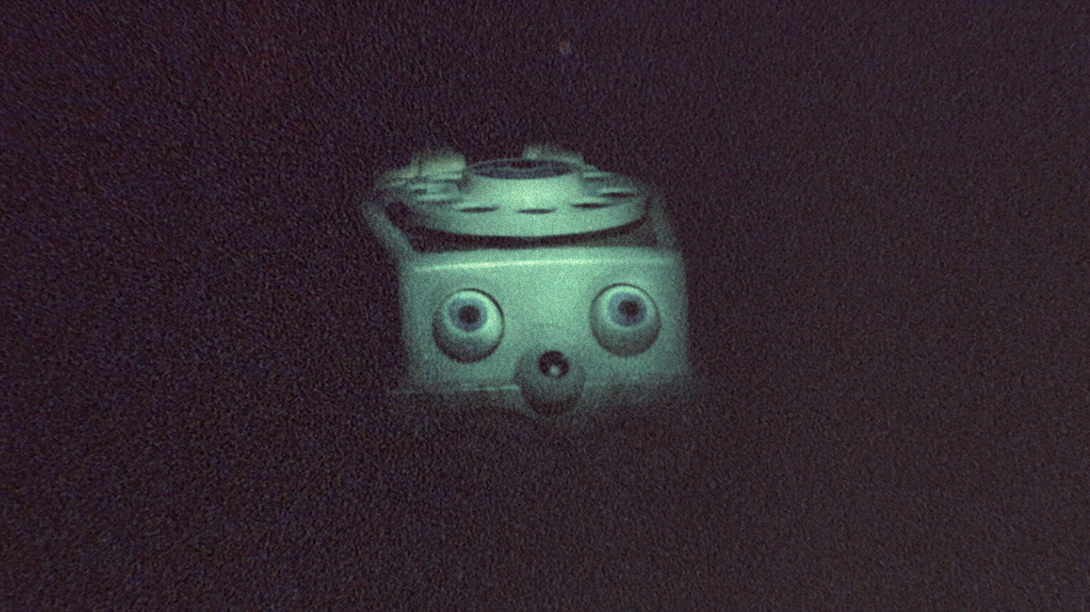 An anthropomorphic toy telephone hidden in the dark.