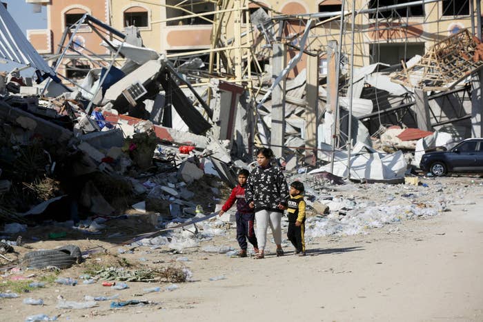 people walking amongst the rubble after buildings were bombed