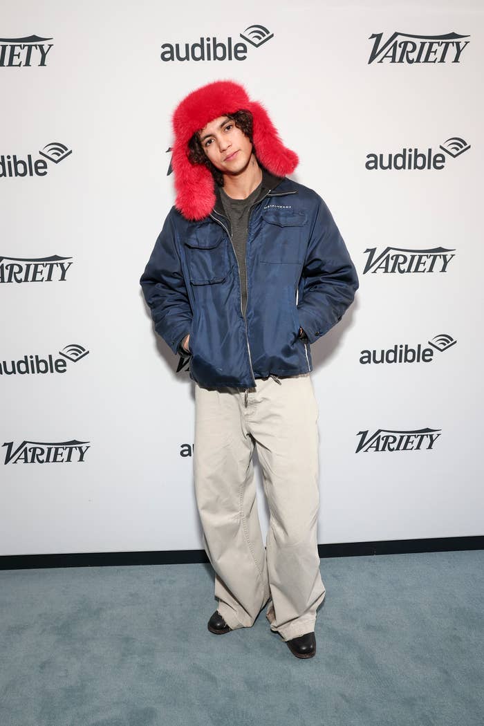 Dominic wearing a fuzzy hat and a jacket at a variety event