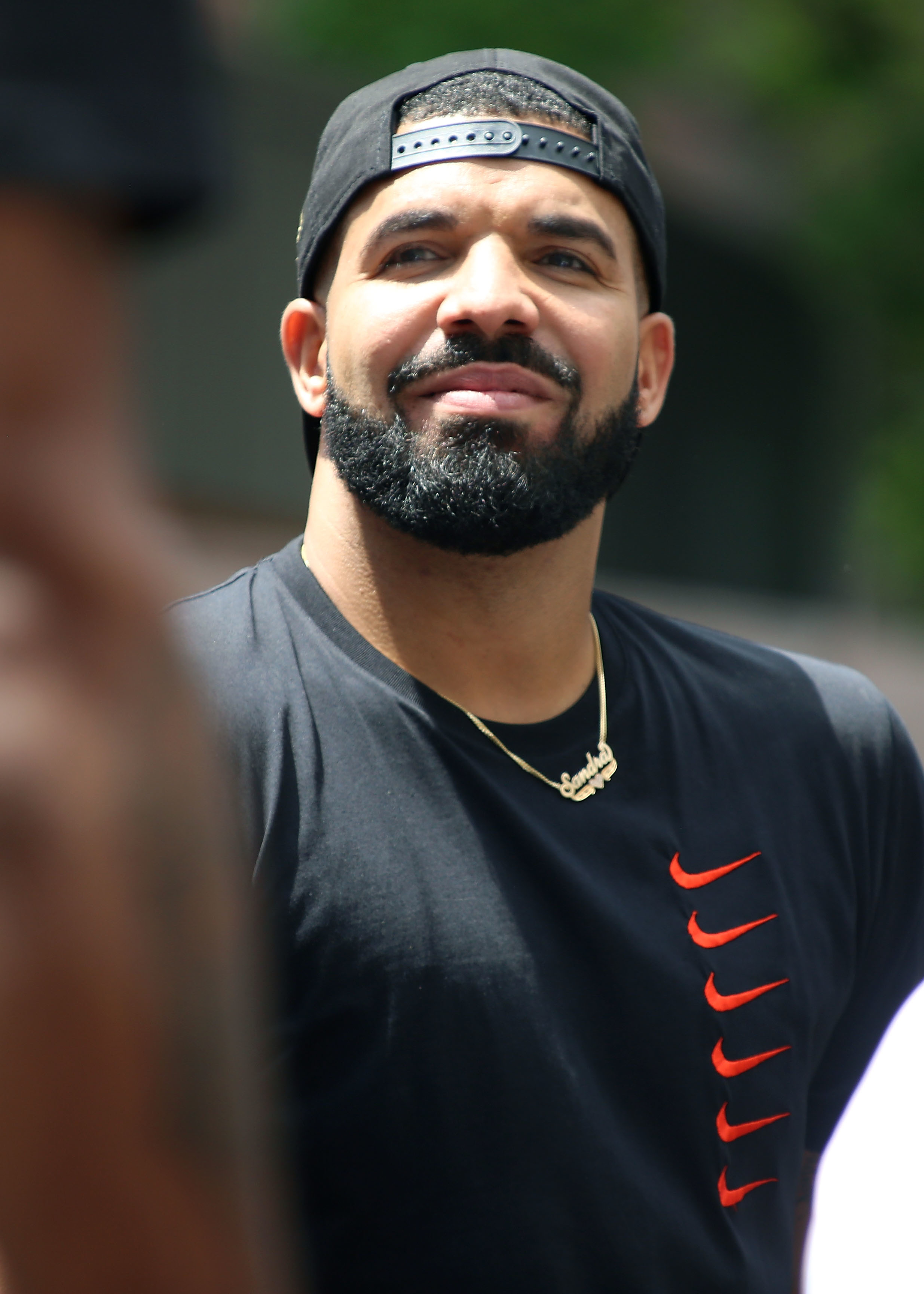 Closeup of Drake wearing a cap backwards