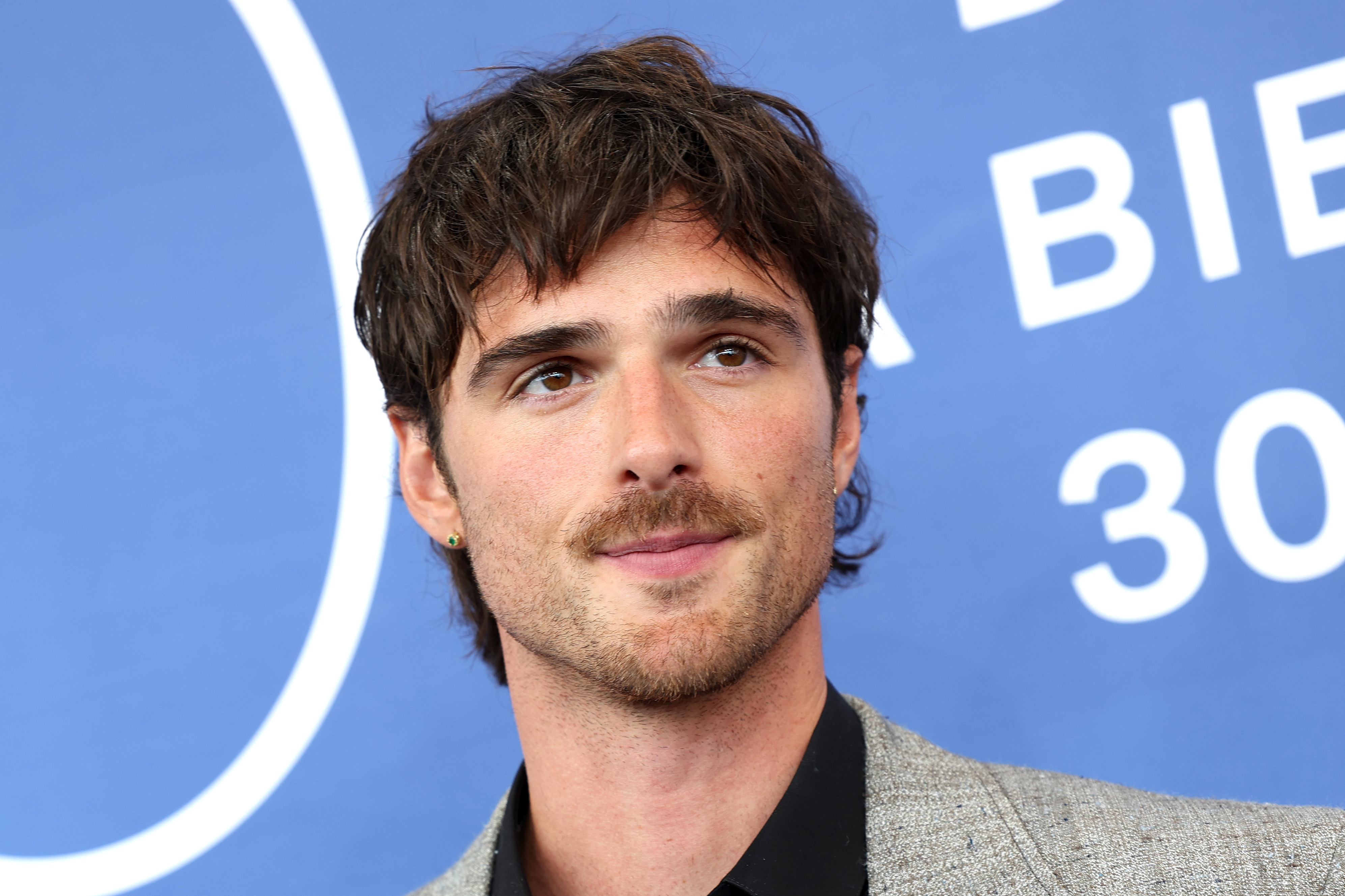 A close-up of Jacob with a mustache at a media event