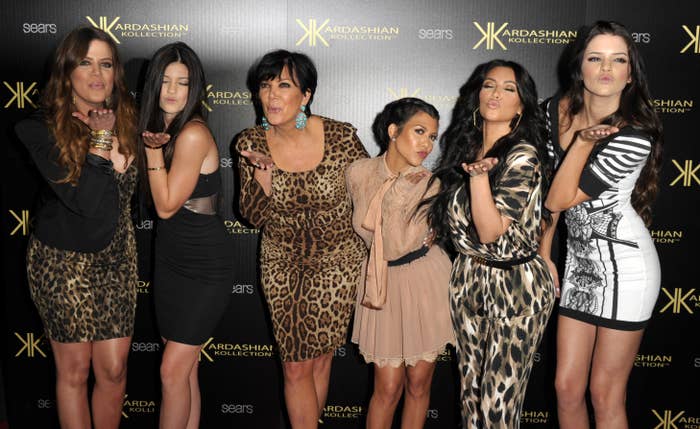 Kris Jenner and her daughters all blowing a kiss to the camera as they stand on the red carpet