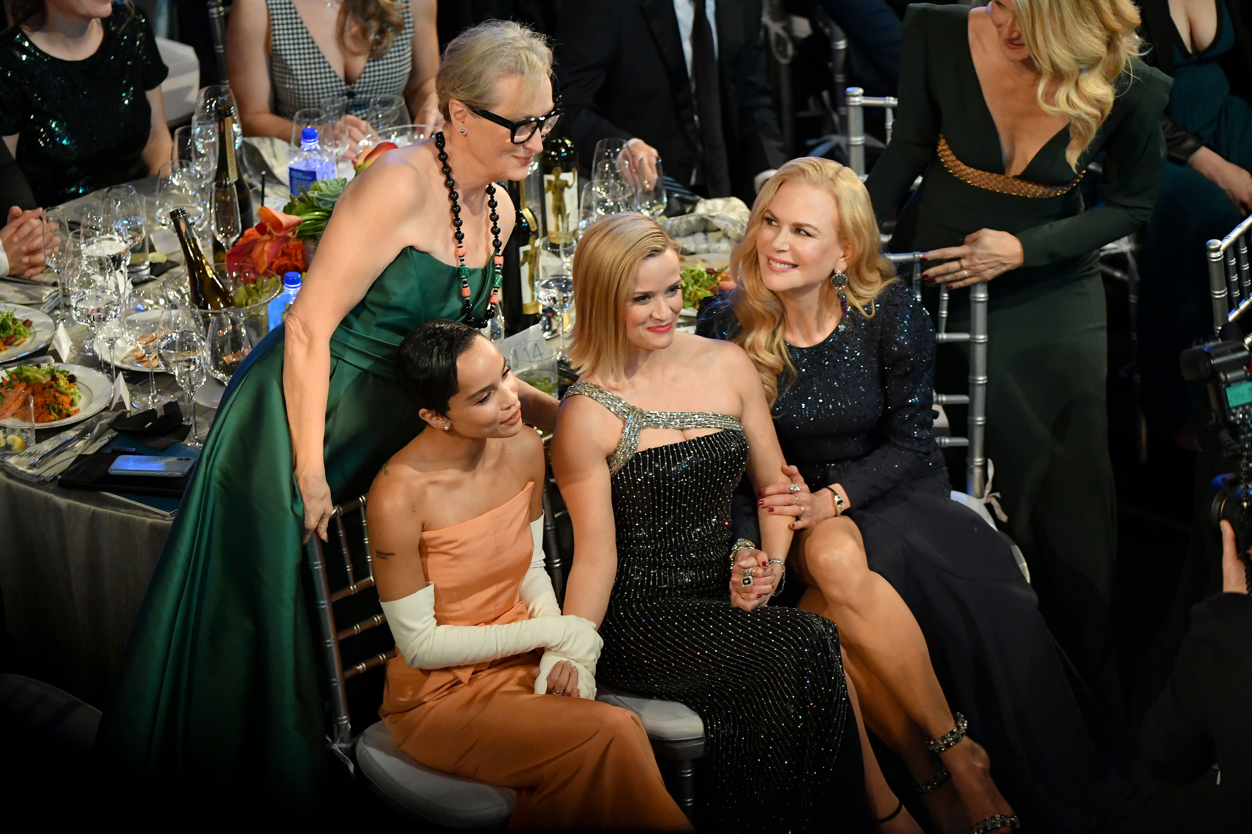 Meryl standing above seated Zoë, Reese, and Nicole at an event