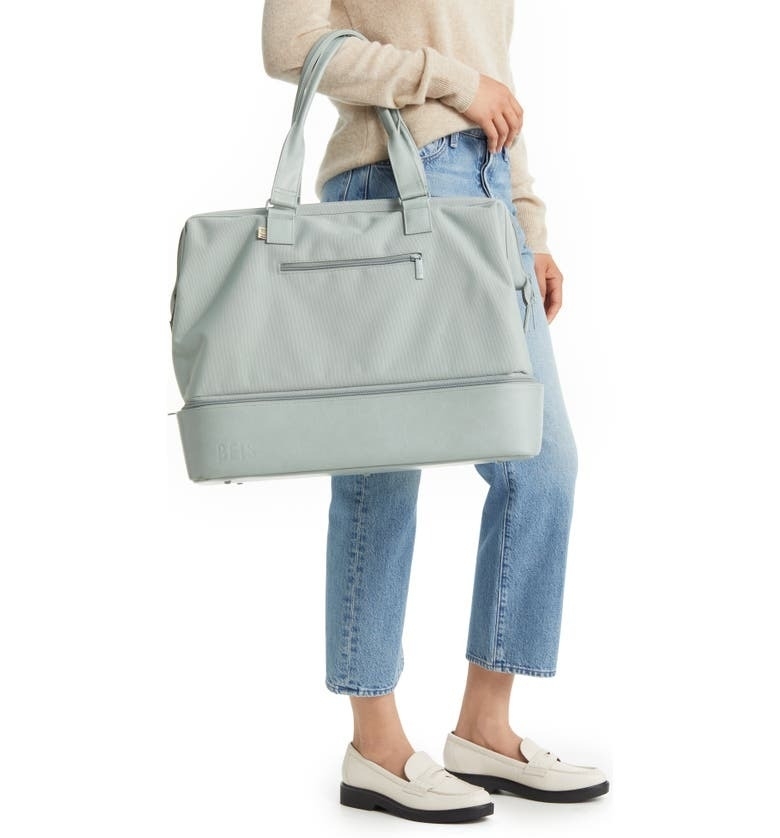 model carrying the light blue Beis weekender bag